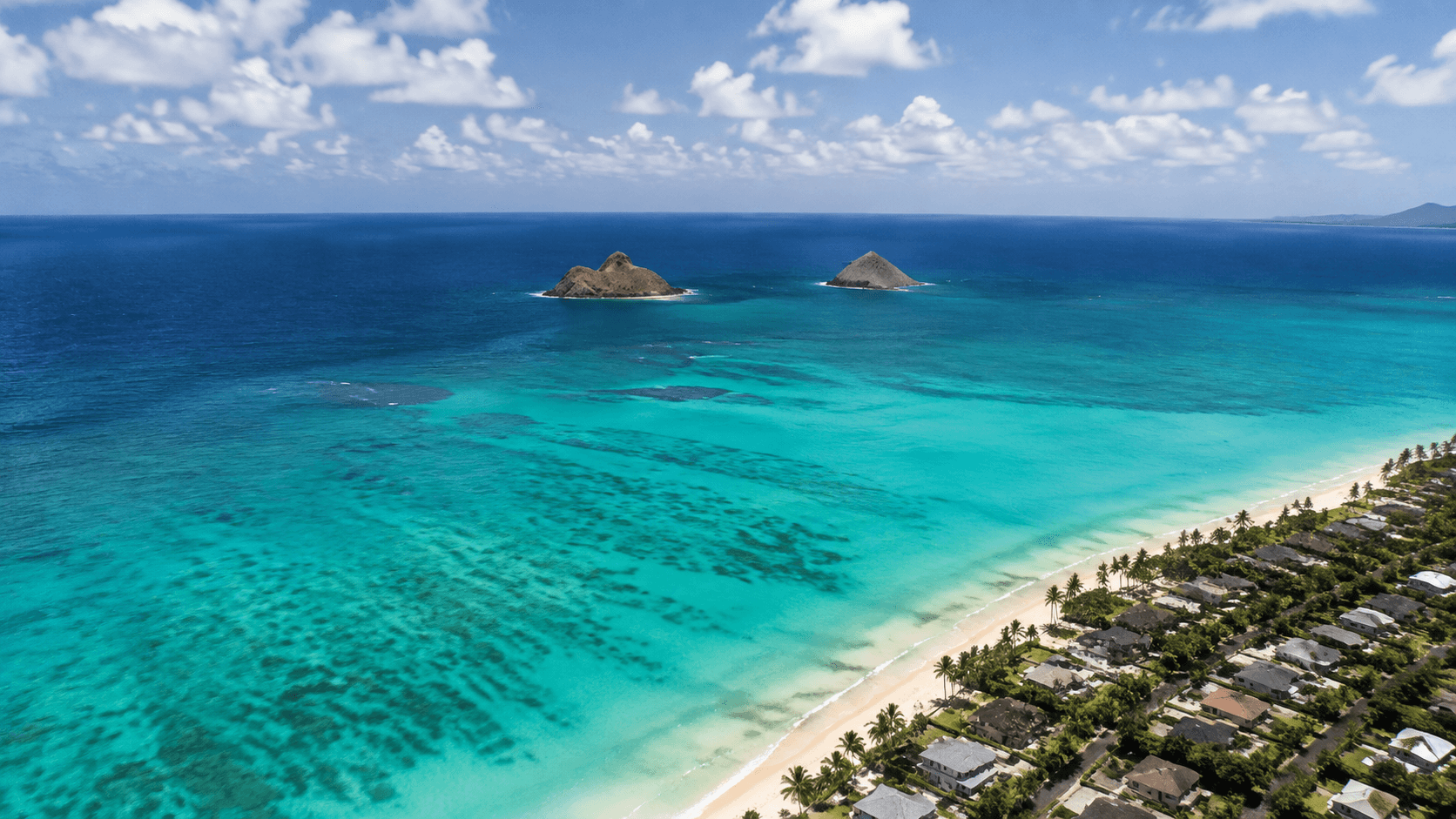 Aerial helicopter view of Lanikai-style turquoise water and offshore islets on Oahu